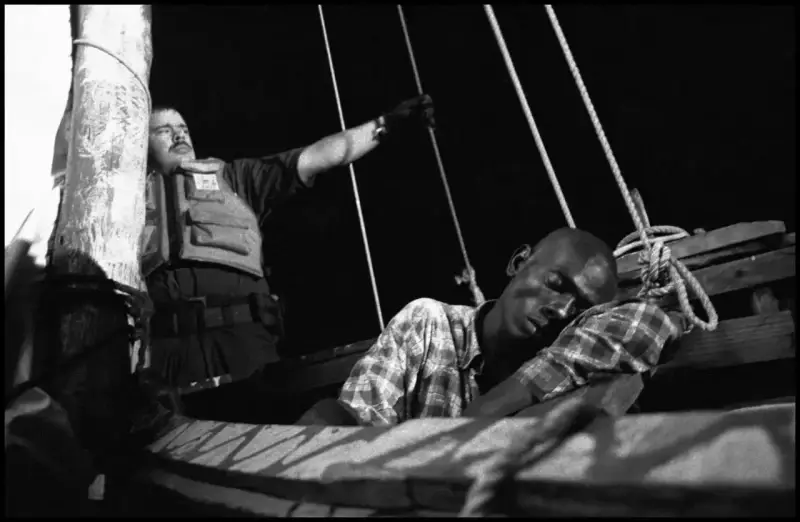 A Haitian man drifts in and out of consciousness from dehydration. He was too  weak to stand and had to  be carried from the boat by the coast-guard who came to the rescue as the 'Believe in God' began to sink. Haiti. 2000 © Christopher Anderson, Альбом: Christopher Anderson, Haiti. Immigrants Trip to America.